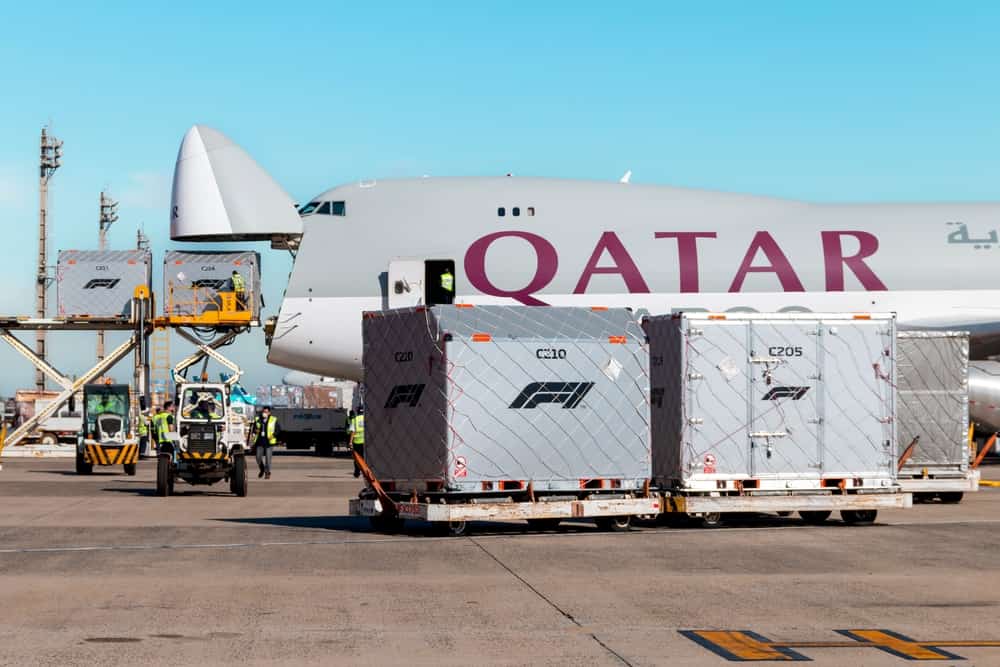 Auf dem Flughafen wird eine mächtige Boeing 747-8 mit offener Frontklappe be- und entladen.